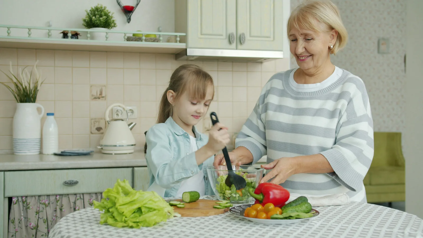 Older adult and child preparing vegetables together