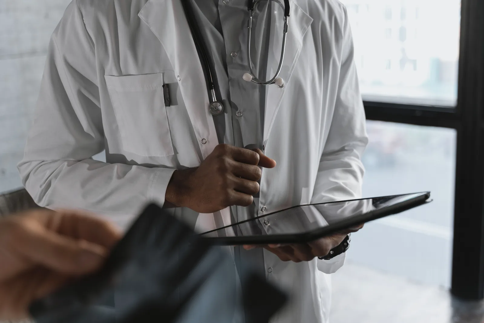 Doctor holding a tablet during a medical consultation