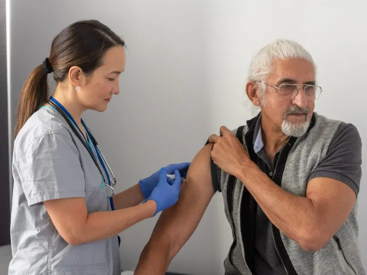 A clinician administering a vaccine to an older adult