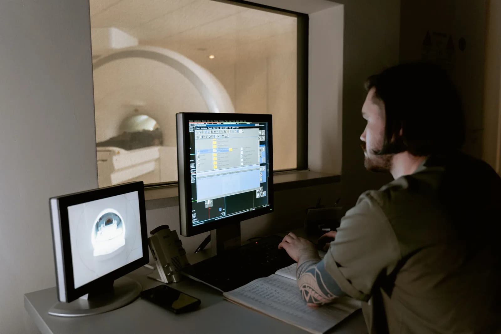 Technologist monitoring a patient during a CT scan from the control room